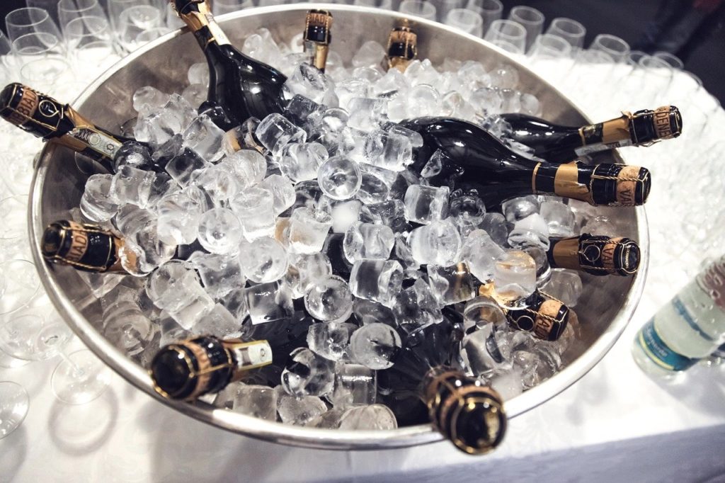 Champagnerschale mit Eiswürfeln und Sektflaschen