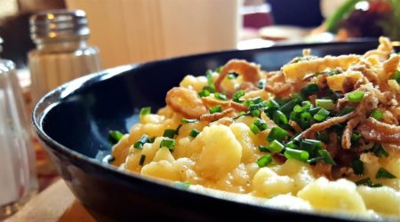 Käsespätzle mit Röstzwiebeln und Schnittlauch in einer Detailaufnahme