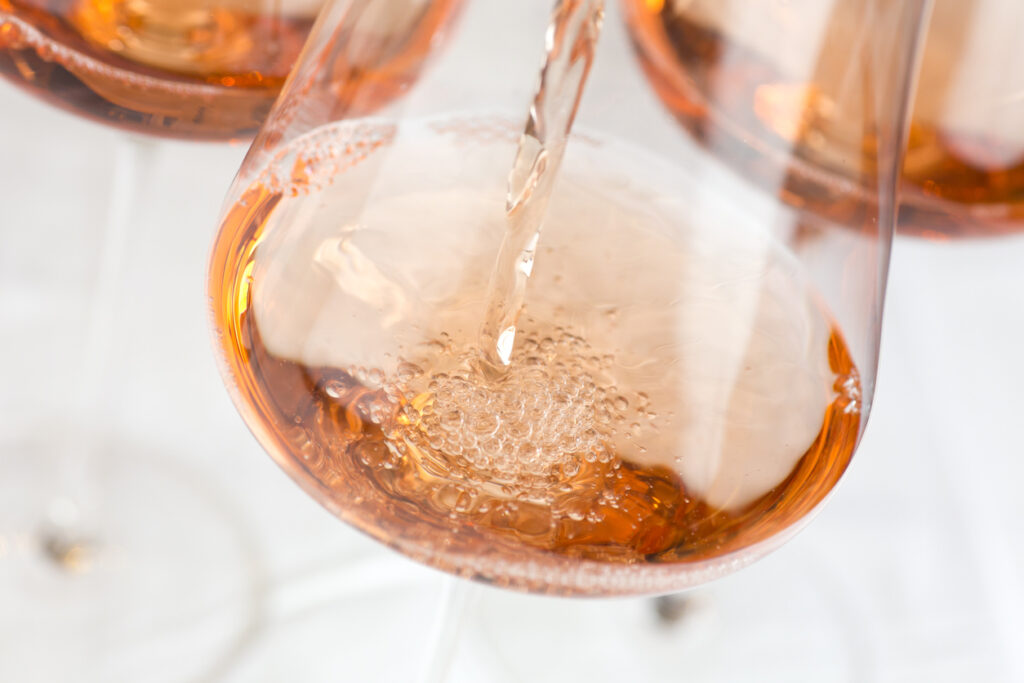 Nahaufnahme: In ein Weinglas wird Rotling eingegossen