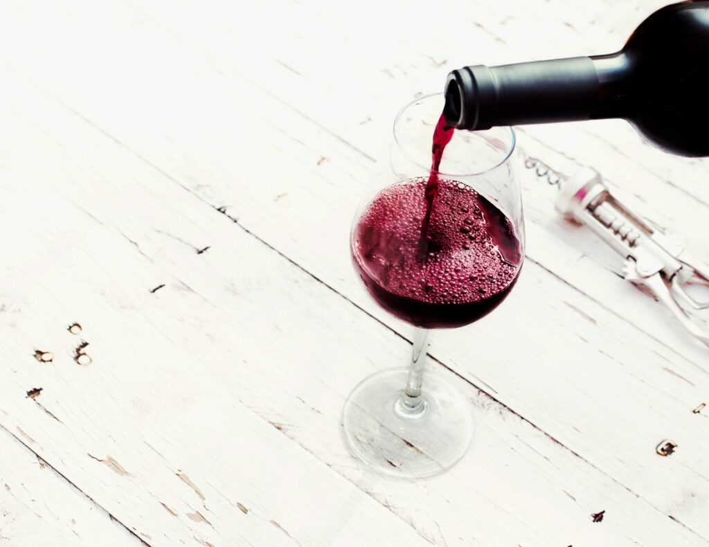 Geschützte Ursprungsbezeichnung: Rotwein wird in ein Weinglas gegossen