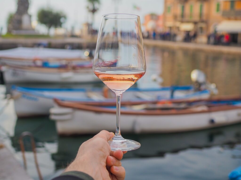 Ein Glas Roséwein an einem Hafen am Gardasee genossen